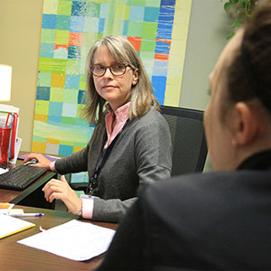 an advisor in an office talking to a student.